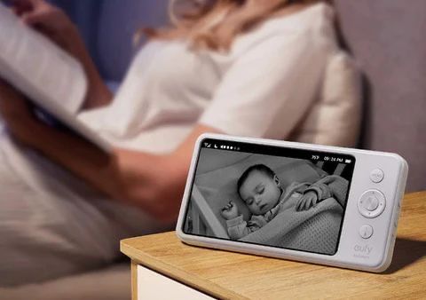 Une mère sereine et un babyphone montrant un bébé qui dort